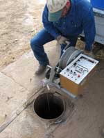 Man taking a water quality sample from a town well
